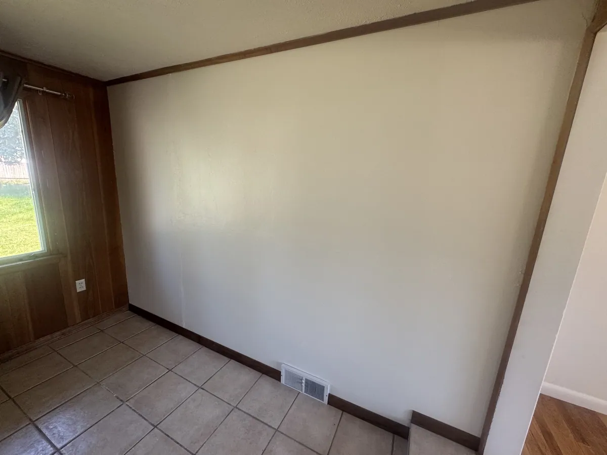 Hallway after wallpaper removal, patching and repainting, with original tile floor