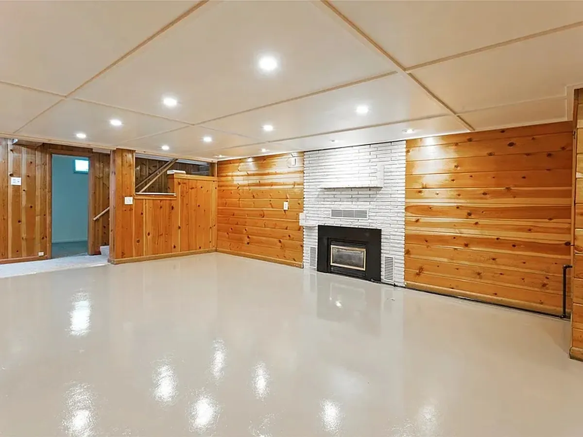 Basement living room with epoxy coated floor and new recessed lighting