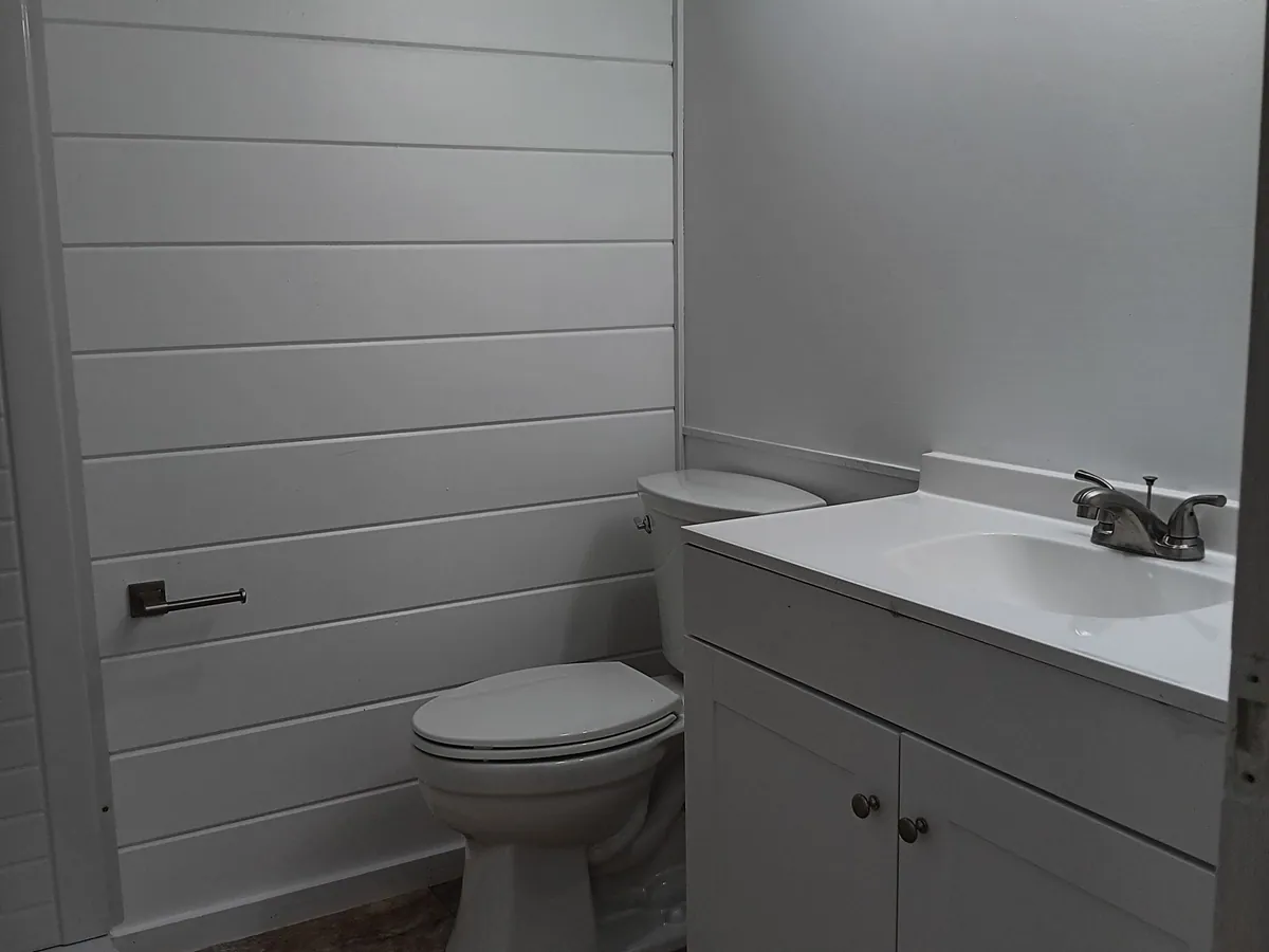 New vanity, sink and faucet installed with finished wall treatment
