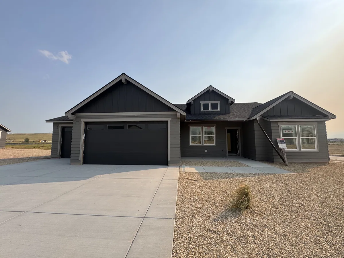 Completed two-tone craftsman home with dark board-and-batten gables and a covered entry