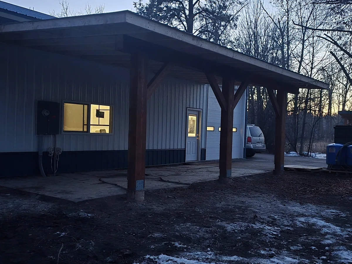 The same timber covered porch photographed at dusk with the interior lights on